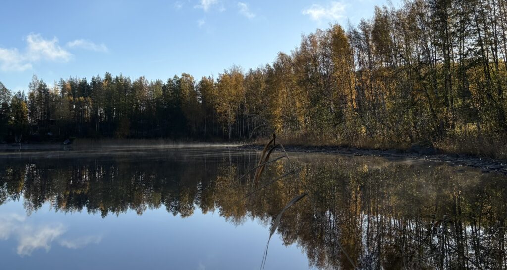 Autumn colours reflected on calm Lake Saimaa in Puumala