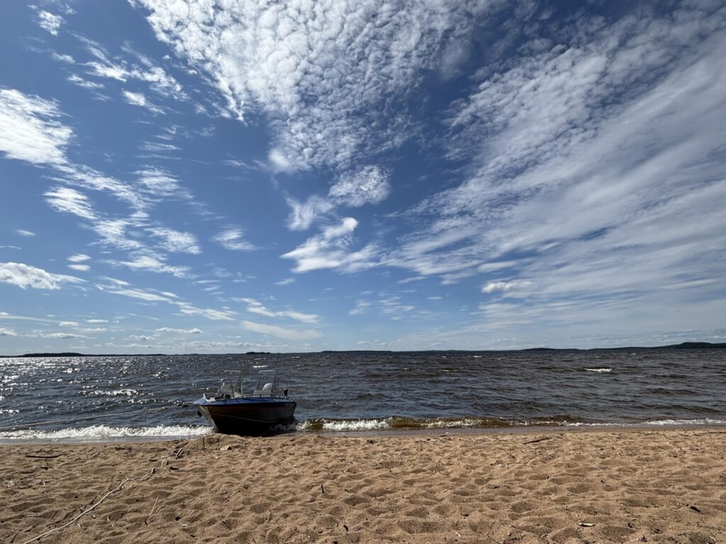 Boat on a sandy Lake Saimaa beach under a summer sky